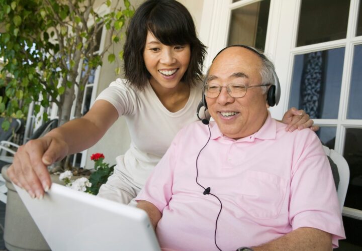 older man wearing headset to talk to ipad