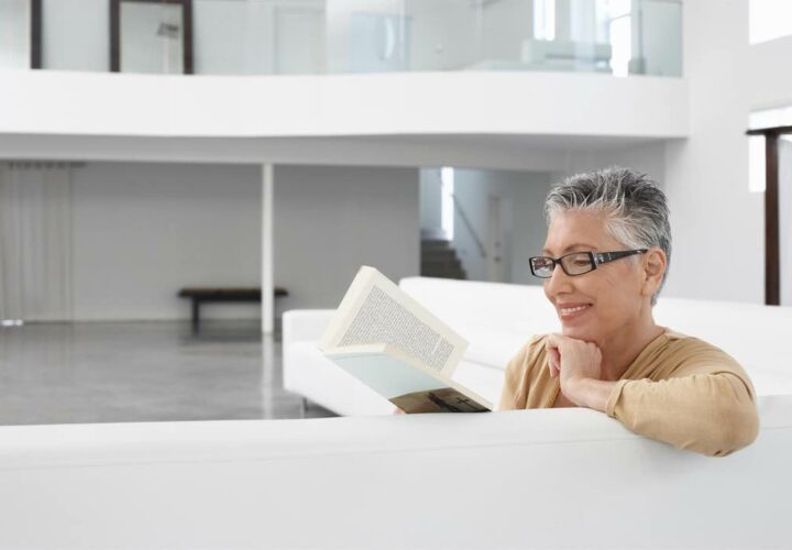 senior woman reading on couch