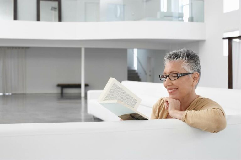 senior woman reading on couch
