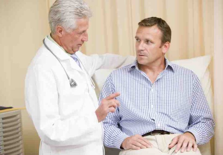 Doctor giving man checkup in exam room