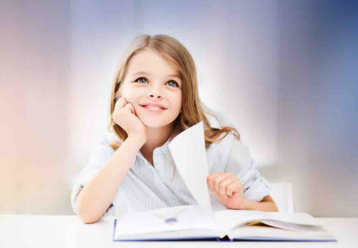 young girl sitting at desk in classroom