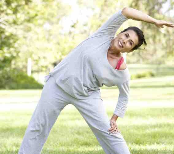 woman in her 60's exercising in a park