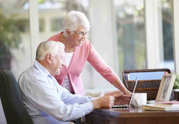 senior woman and man work on laptop computer at desk