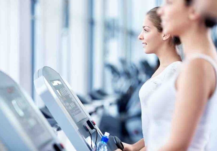 two women walking on treadmills