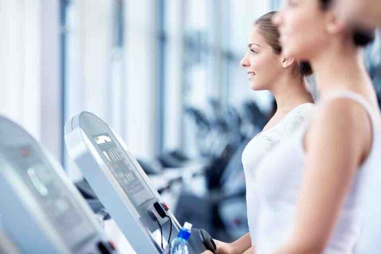two women walking on treadmills